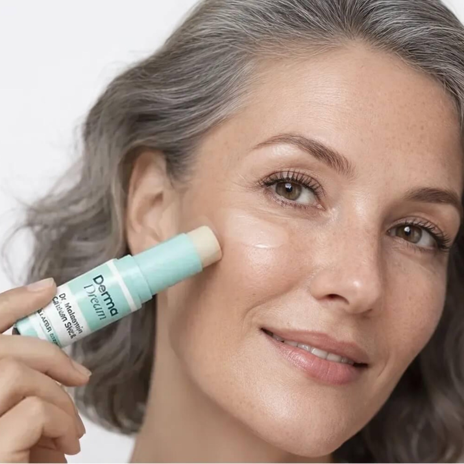 Person applying Dr. Melasmin Calcium Balm to the cheek